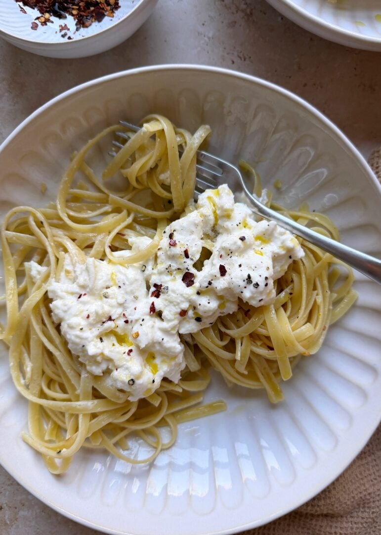 simple stracciatella pasta with noodles wrapped around a silver fork