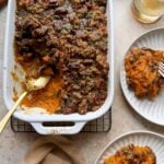 sweet potato casserole with bourbon and brown sugar pecan bacon topping with silver spoon and two servings on the side
