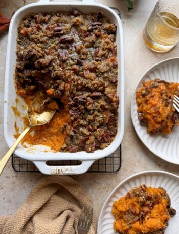 sweet potato casserole with bourbon and brown sugar pecan bacon topping with silver spoon and two servings on the side