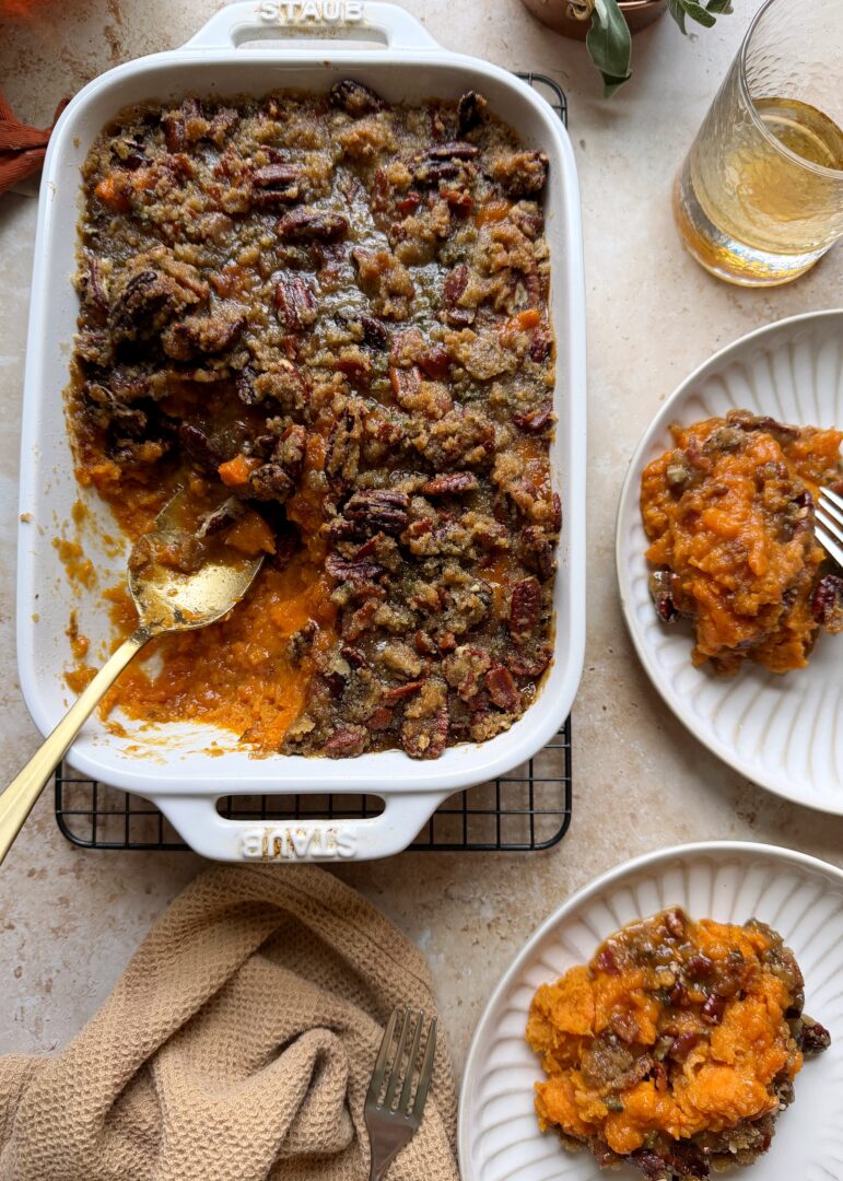 sweet potato casserole with bourbon and brown sugar pecan bacon topping with silver spoon and two servings on the side