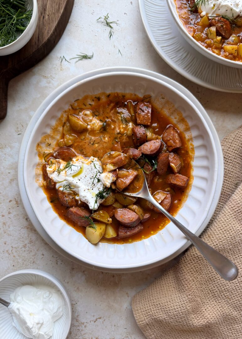 kielbasa potato soup with sour cream and dill with a silver spoon