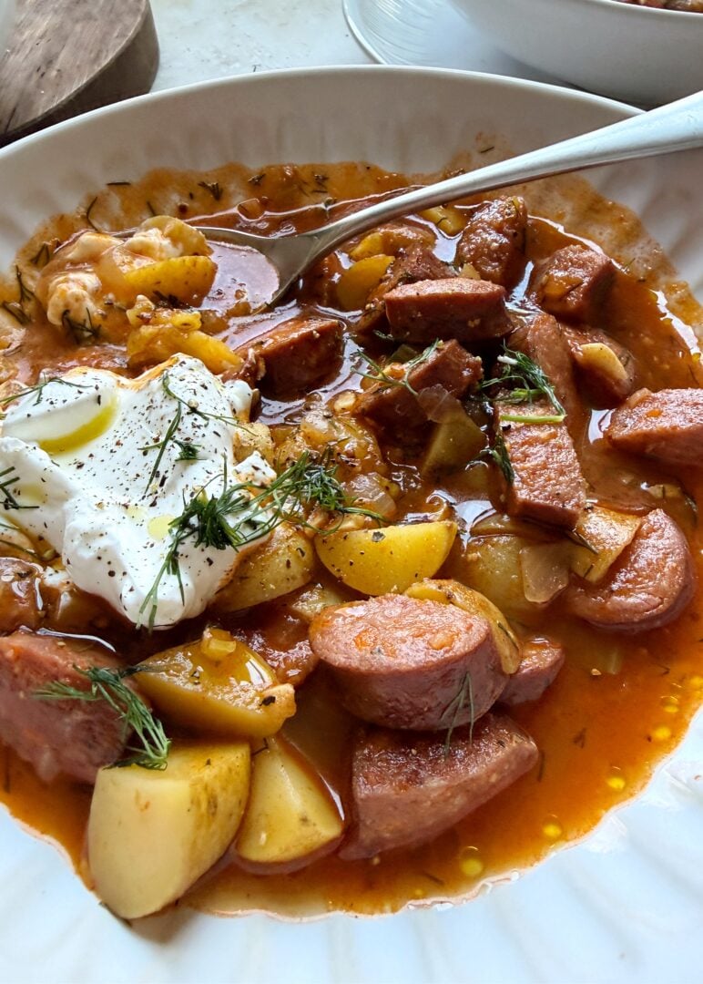 kielbasa potato soup with sour cream dollop and silver spoon