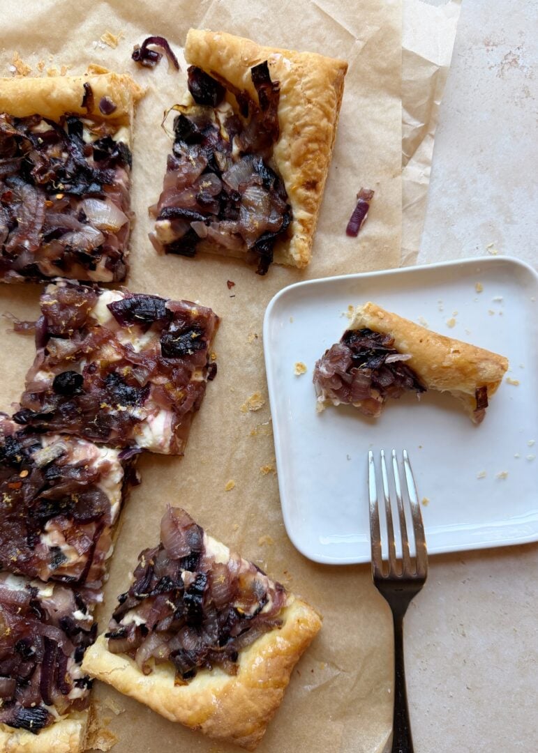 caramelized onion and boursin tart serving partially eating