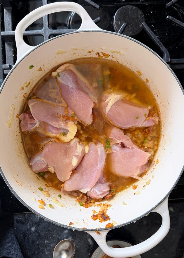 chicken thighs nestled into dutch oven for chili