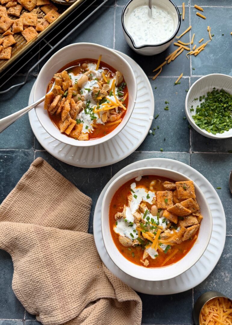 two bowls of buffalo chicken white chili with ranch cheezits