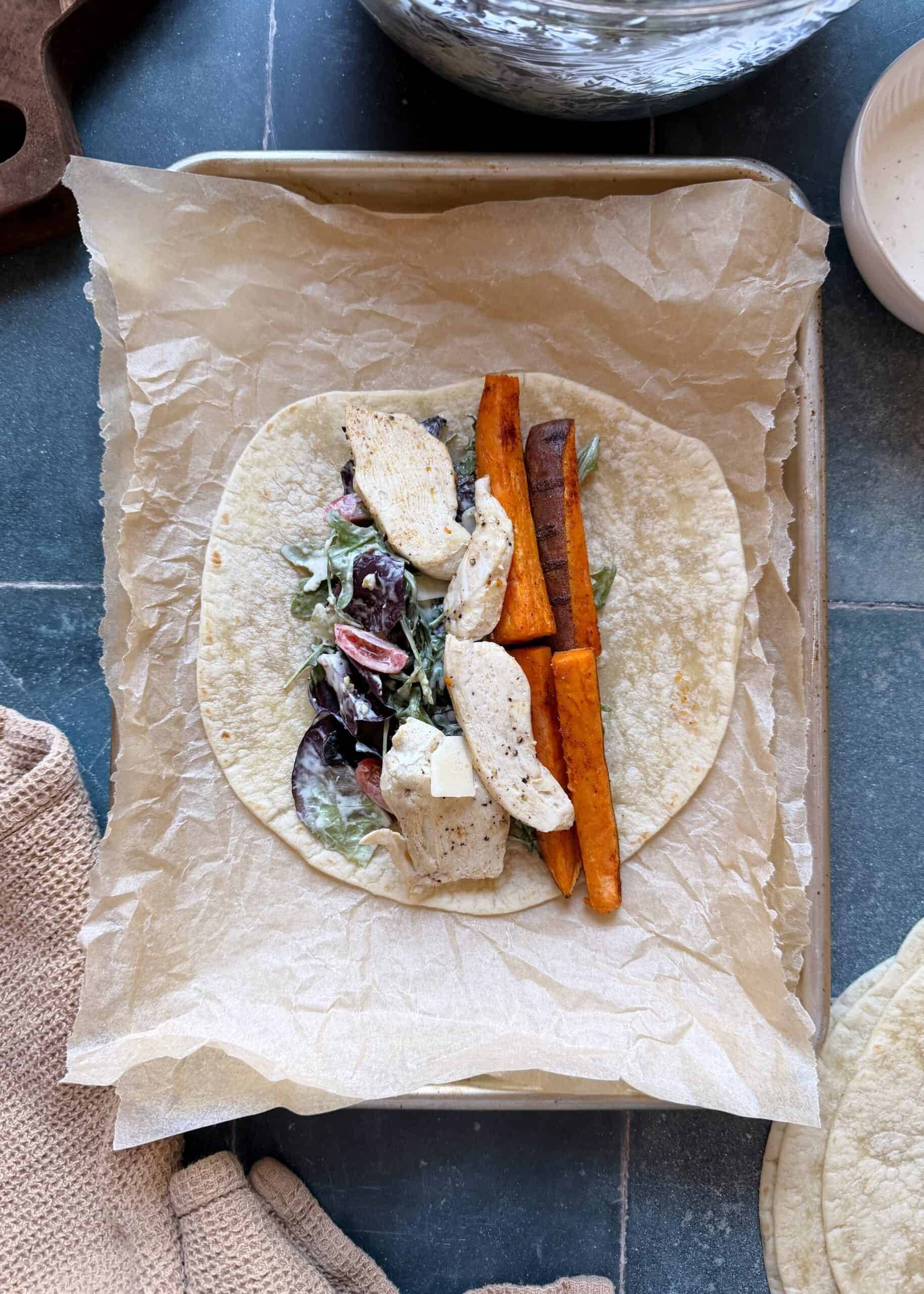 chicken caesar salad with sweet potato fry on a tortilla