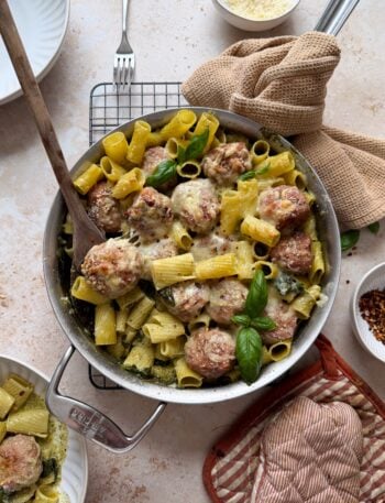 saute pan with cheesy pesto turkey meatballs and rigatoni with bowl on the side