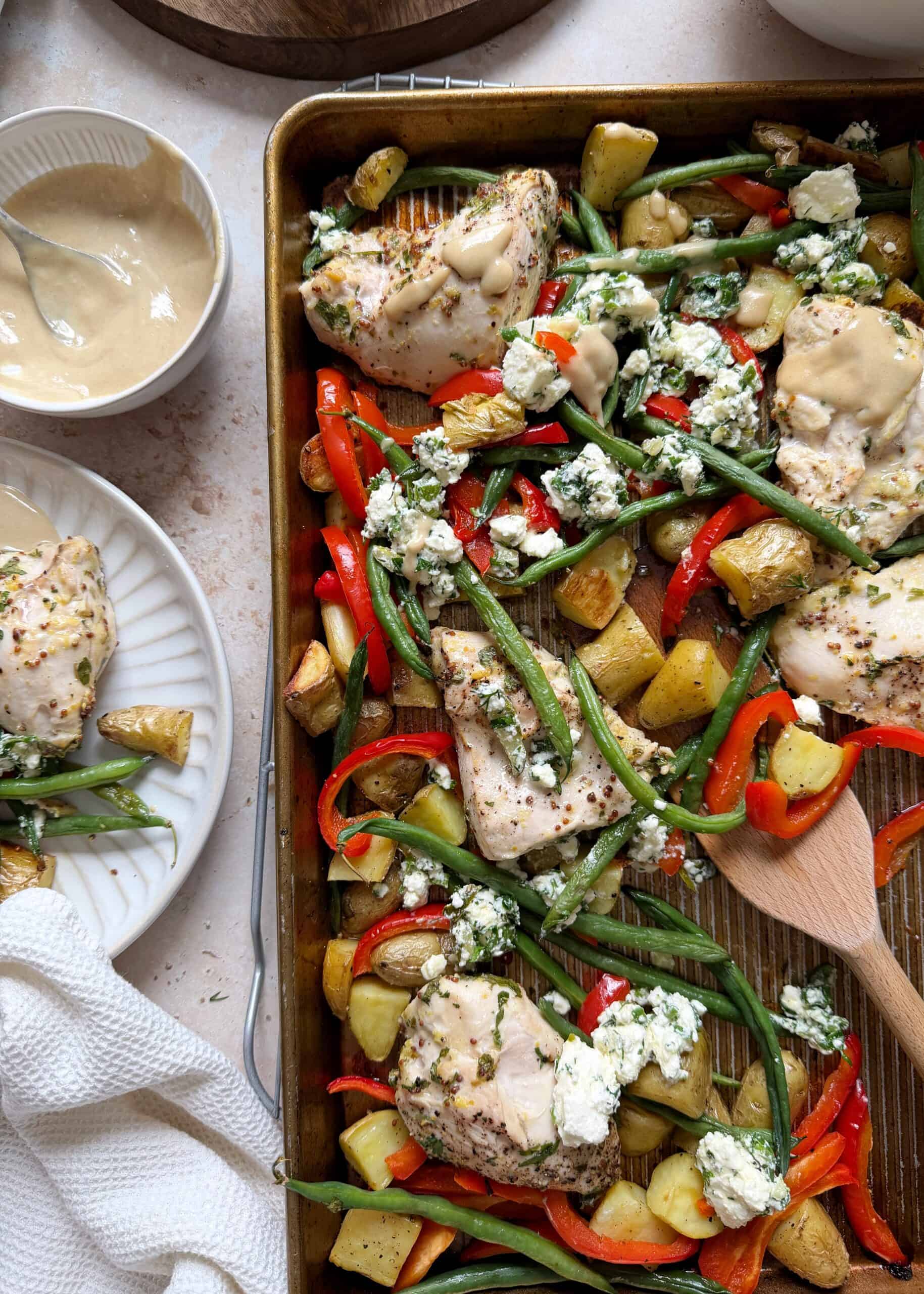 sheet pan mediterranean chicken with feta salad and tahini sauce with serving on the side