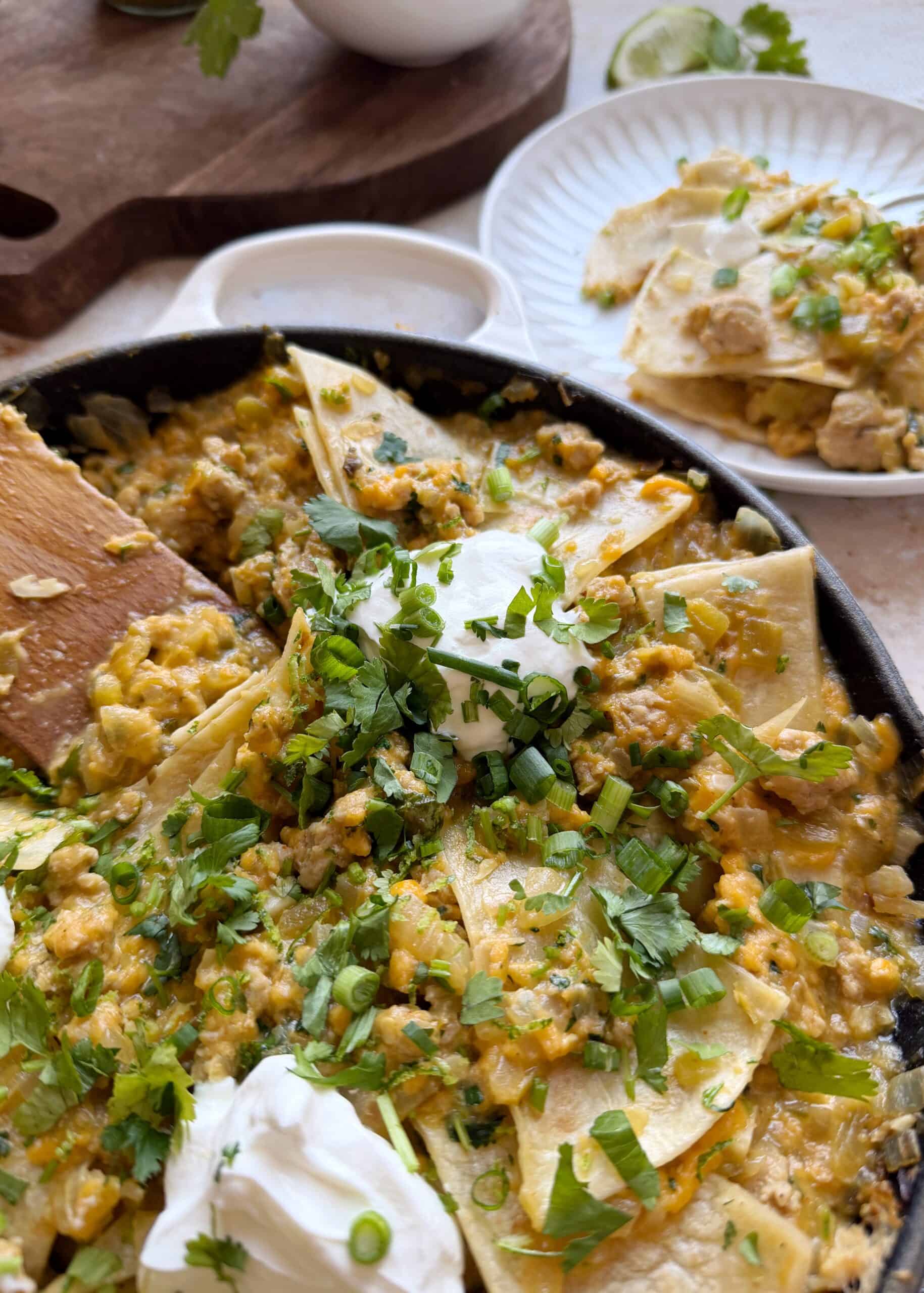green chile chicken enchilada skillet with sour cream and fresh herbs