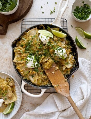 skillet of green chile chicken enchilada with a serving on the side