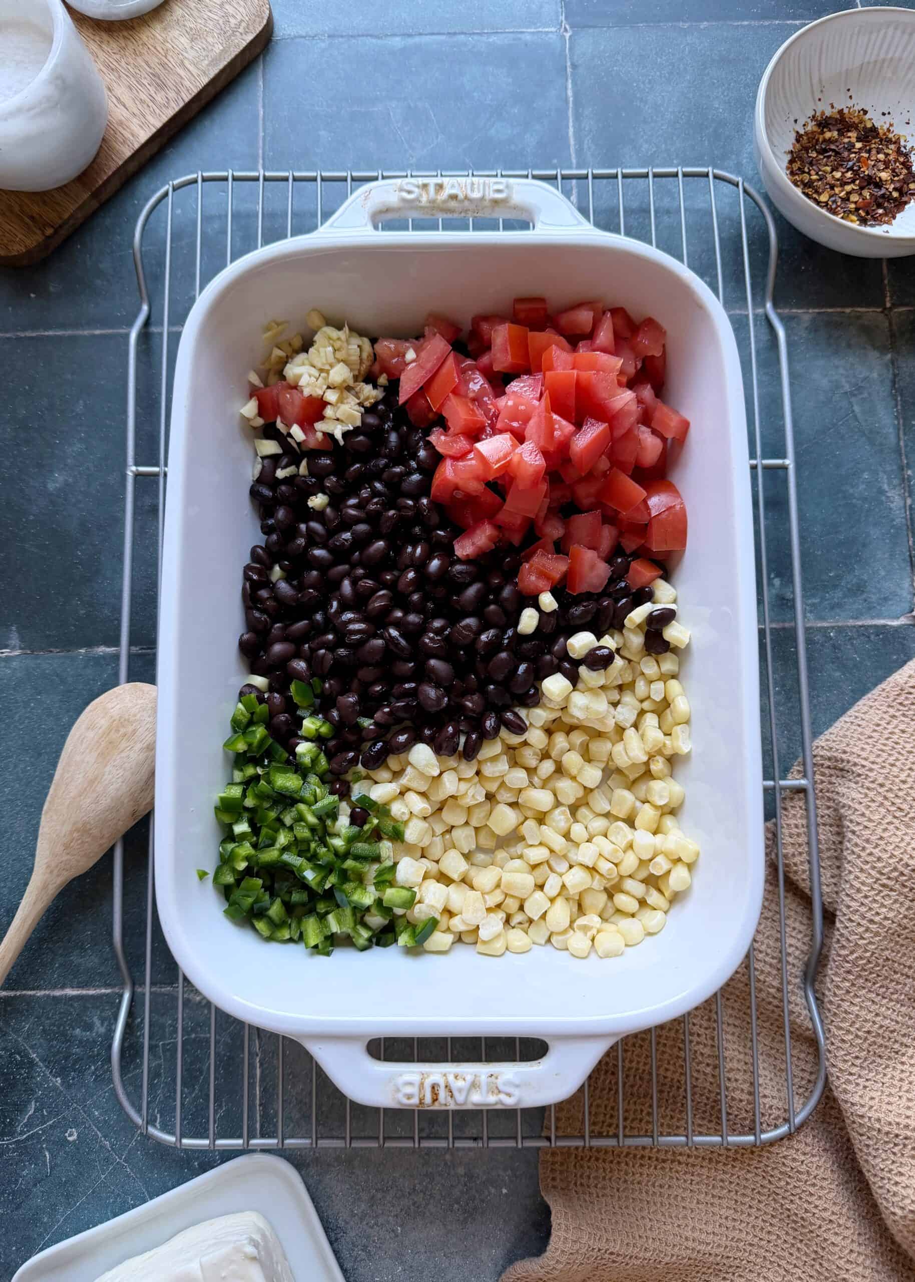 baked black bean corn and feta dip ingredients in white casserole dish