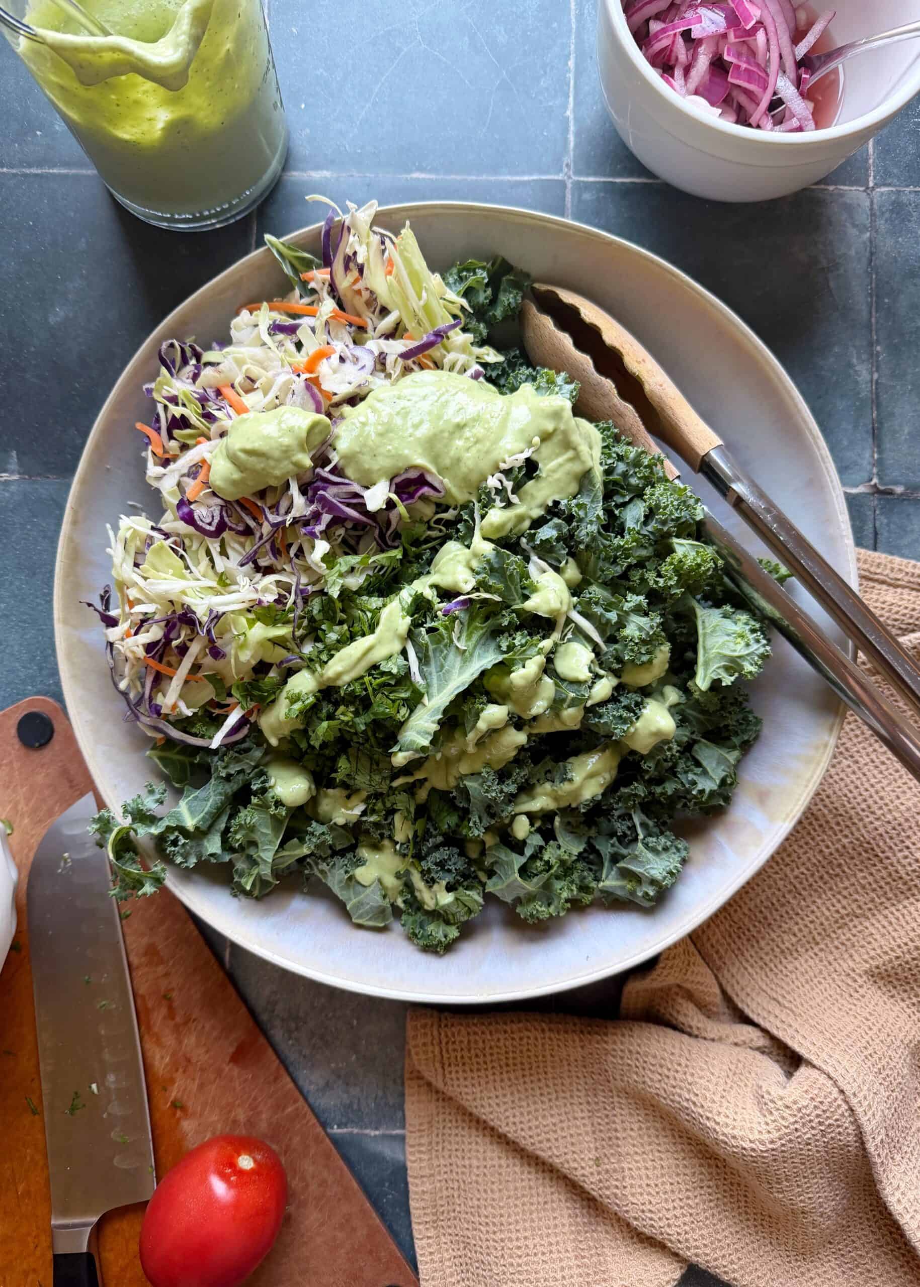 chopped kale and cabbage with avocado greek yogurt dressing in a white bowl