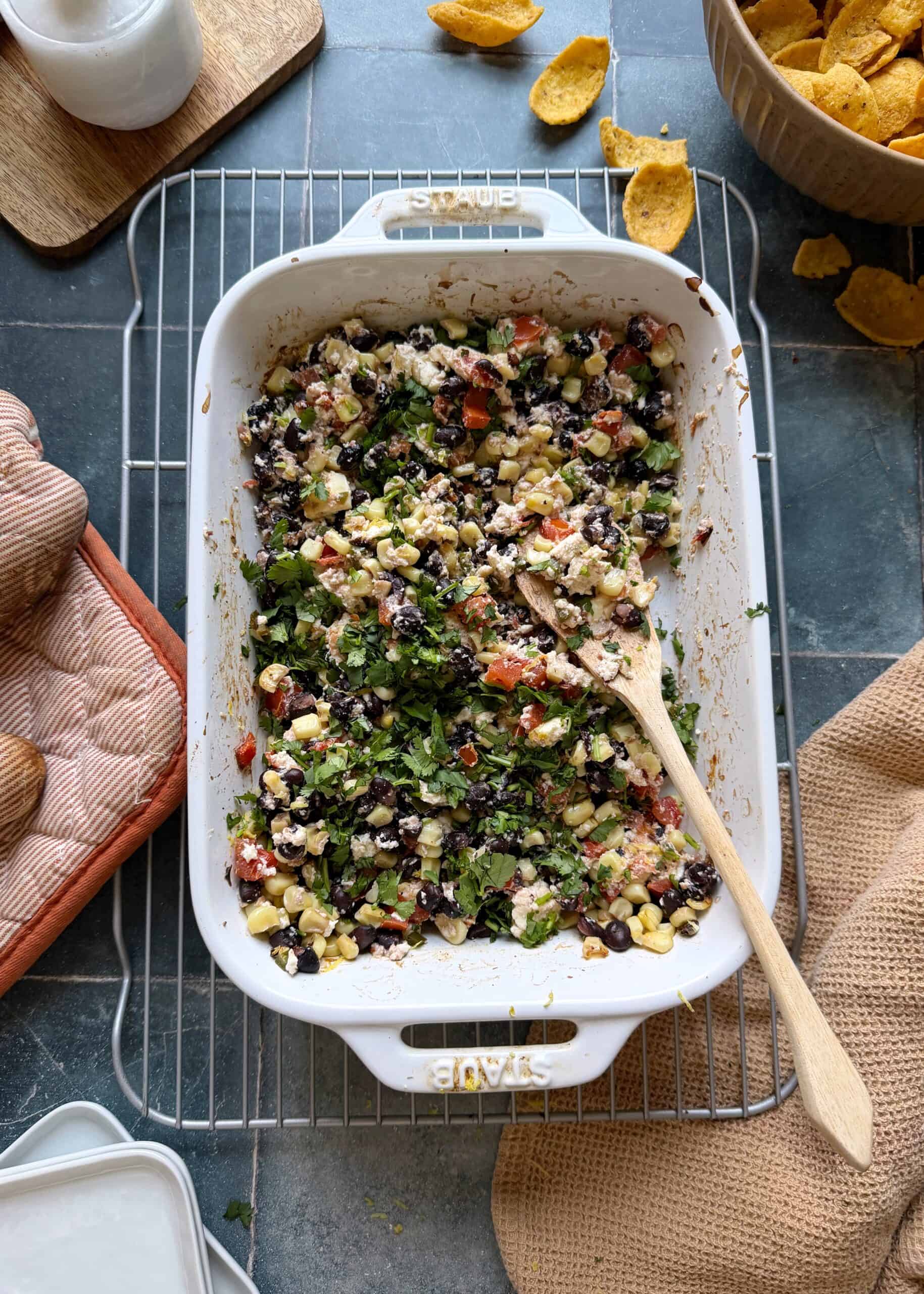 mixed baked black bean corn and feta dip topped with fresh cilantro and served with corn chips