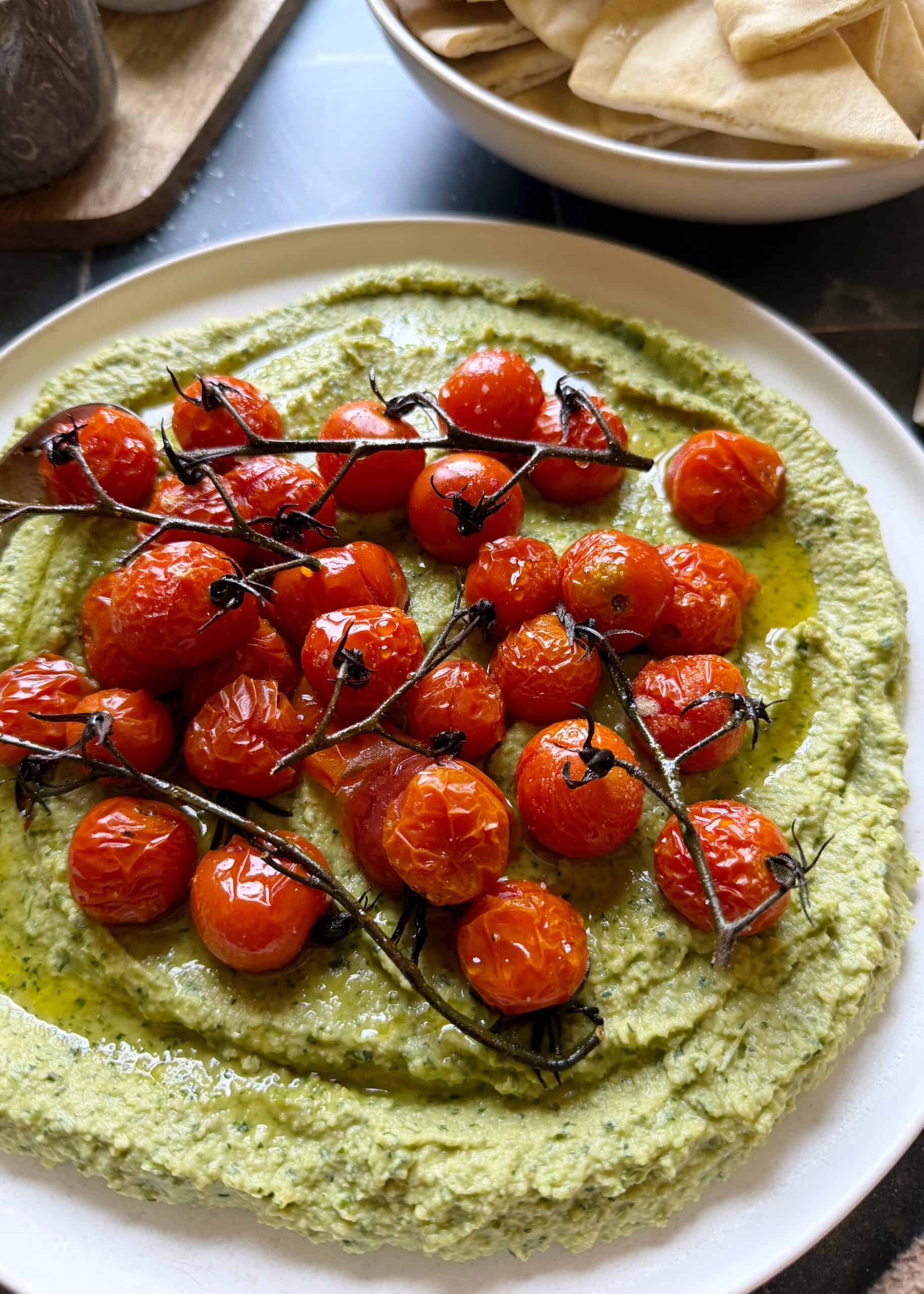 roasted cherry tomatoes on top of herby jalapeno hummus