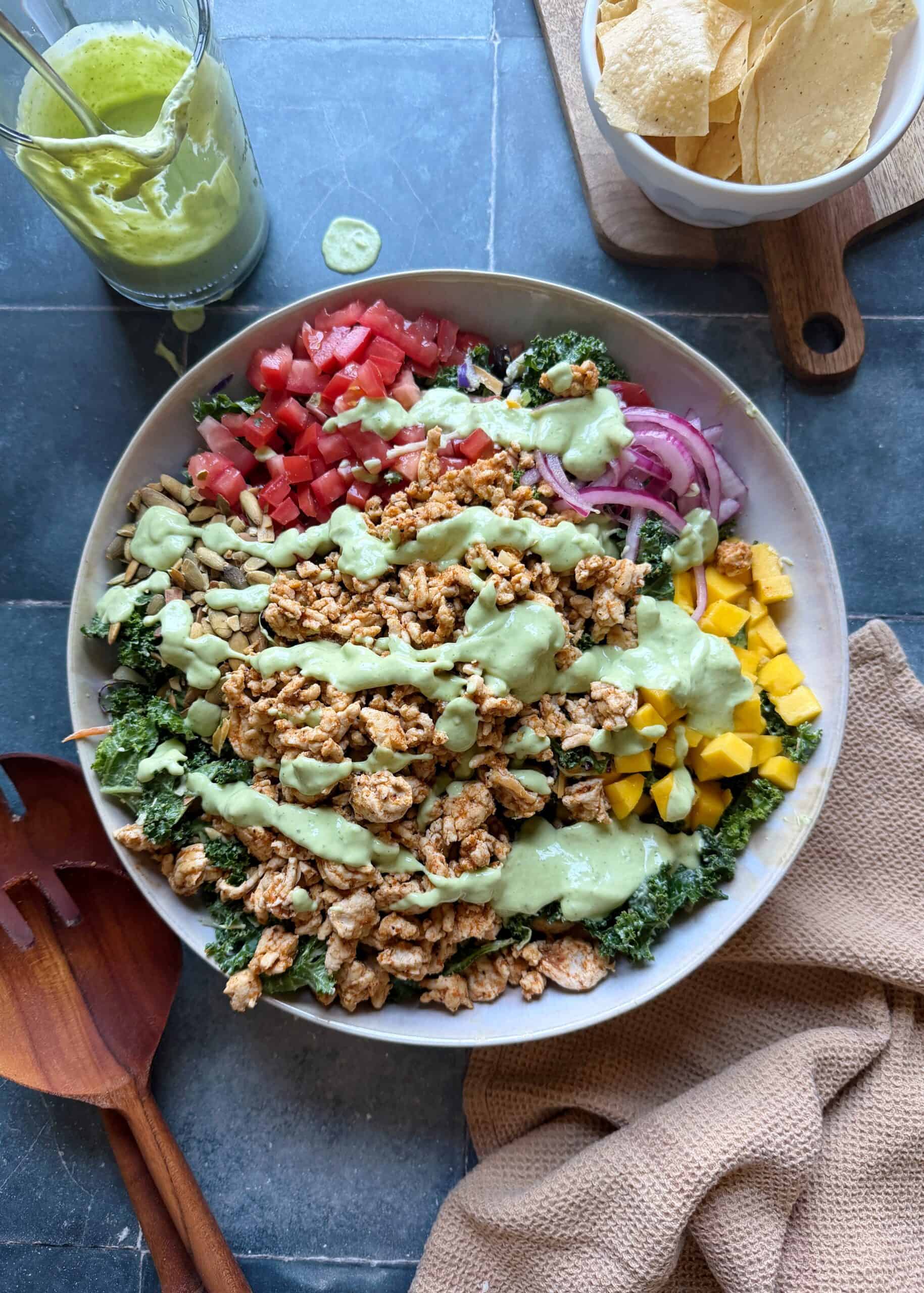 turkey taco salad in a white bowl drizzled with avocado greek yogurt dressing